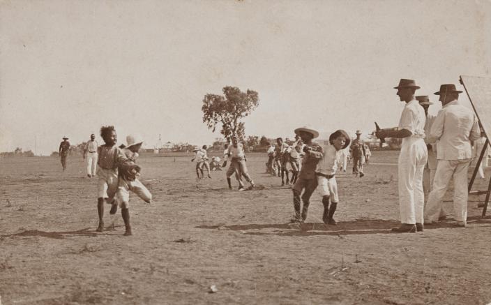 A group of people playing games in a field. 